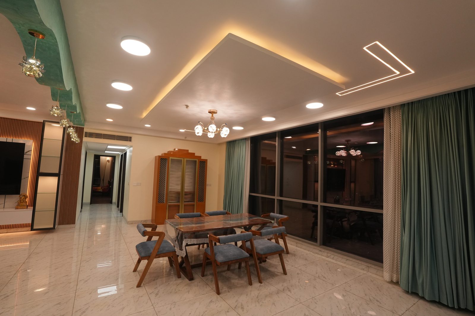 Dining area with chandelier and teal accent wall