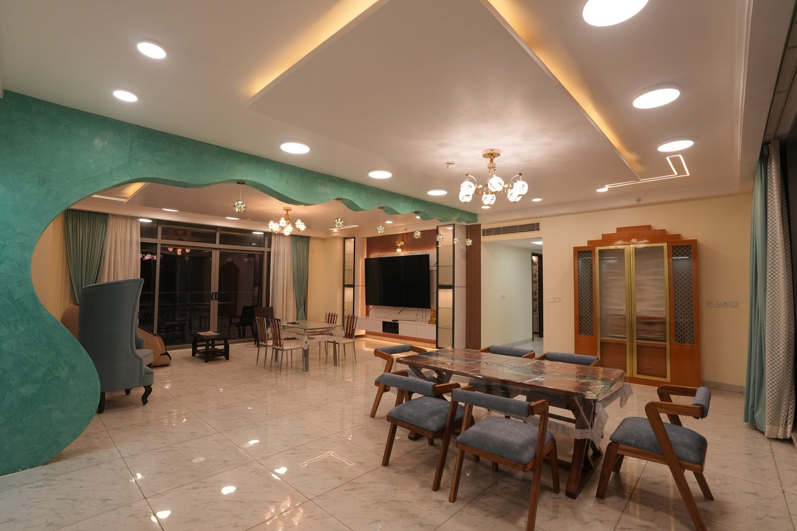 Candidscape premium residential interior at Mantri Pinnacle — open-plan living and dining with sculpted teal feature wall, Bangalore