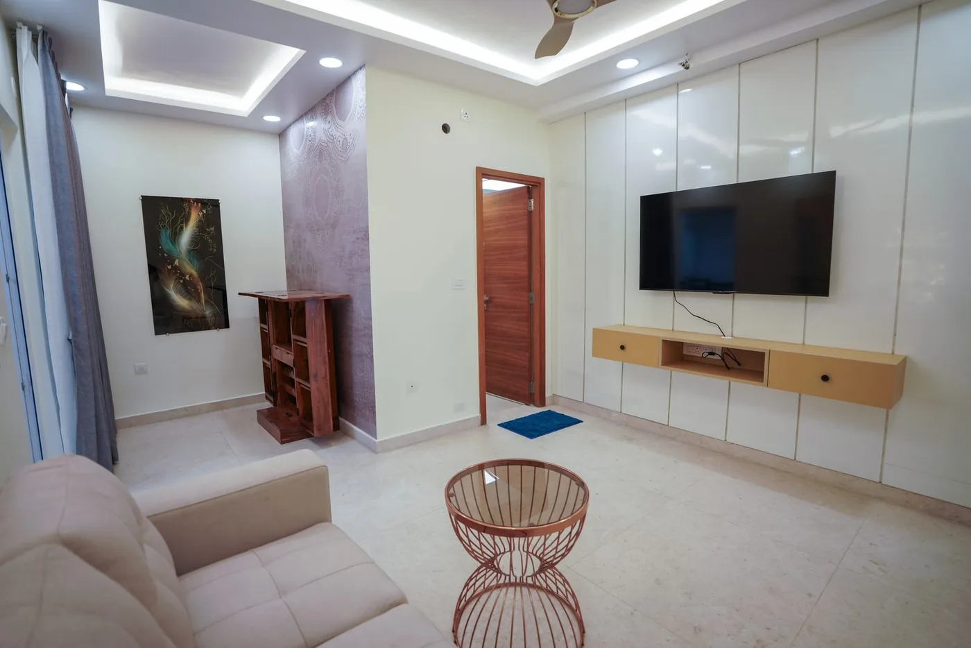 RMZ residence living room with media wall and lounge seating