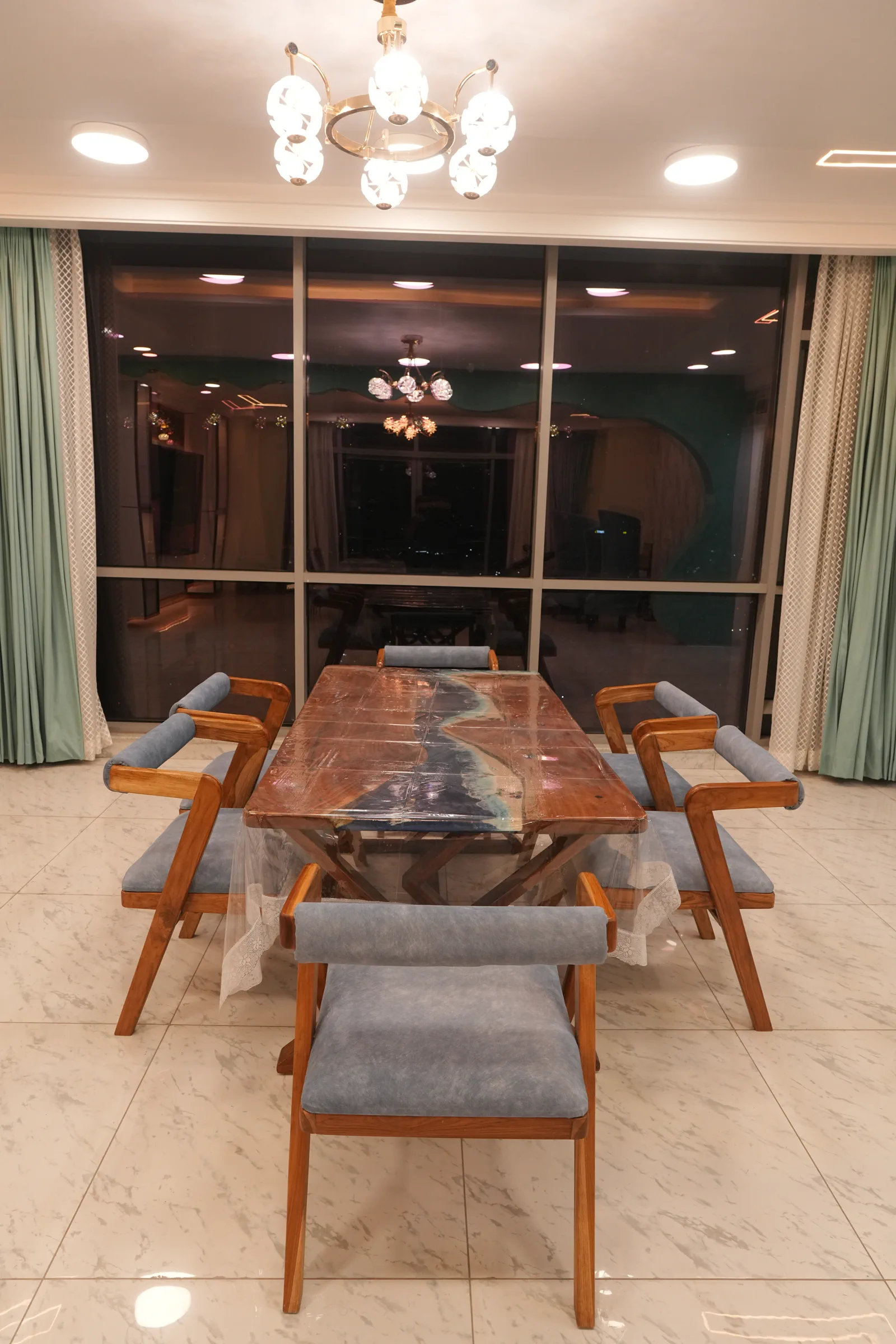 Mantri Pinnacle Dining Table — A resin-inlaid table set against a glazed partition.